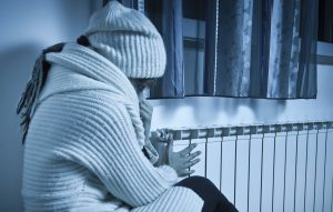 Furnace not heating woman trying to stay warm in cold house.