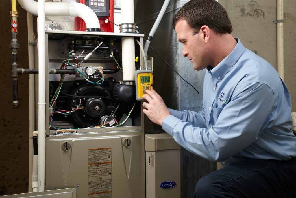 Buy or rent a furnace: an Aire One technician servicing a gas furnace in an Ontario home